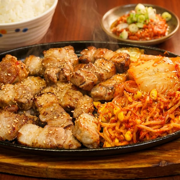 Hot platter of Korean grilled pork belly, kimchi, and spicy bean sprouts with rice.